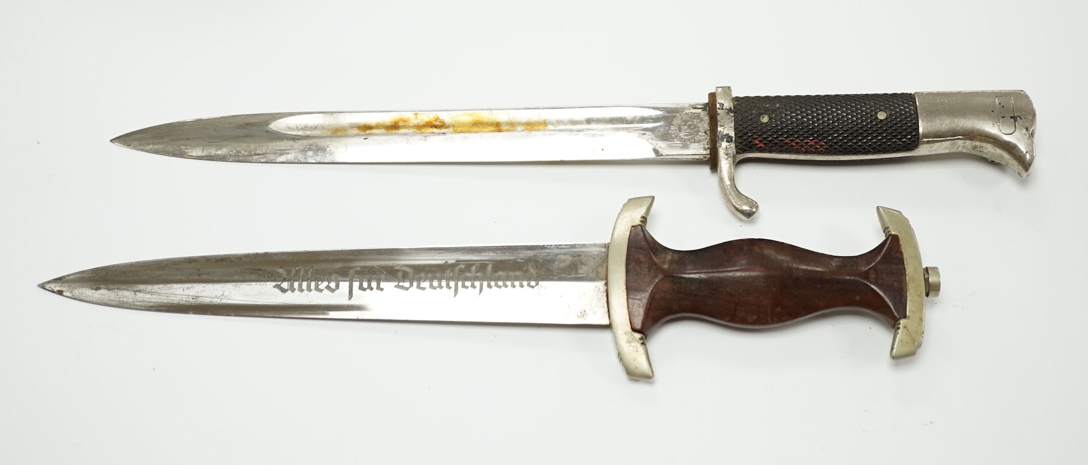 A WWII German SA dagger, regulation pattern in its steel scabbard with regulation nickel mounts, and leather hanging band and a German dress bayonet by Paul Seilheimer. Condition - fair, some wear